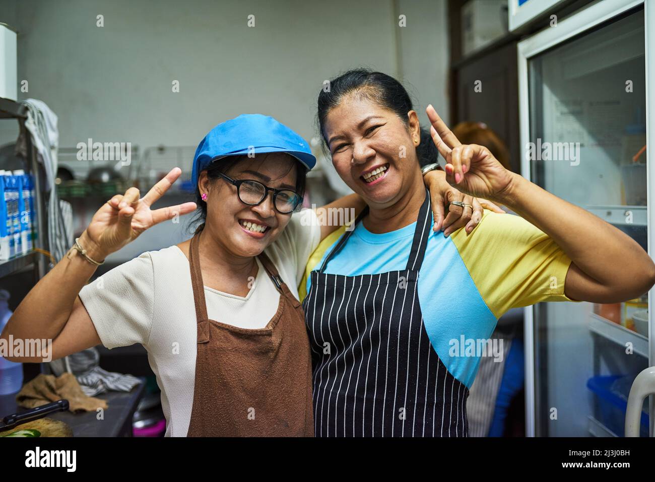 Kitchen buddies. Portrait of two happy cooks posing together in the kitchen. Stock Photo