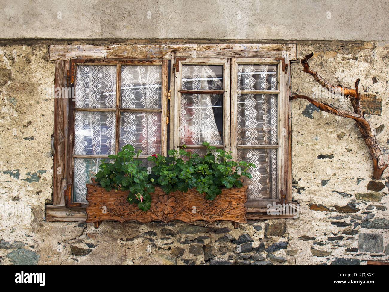Old window of a cracking house with traditional carving window box and ...