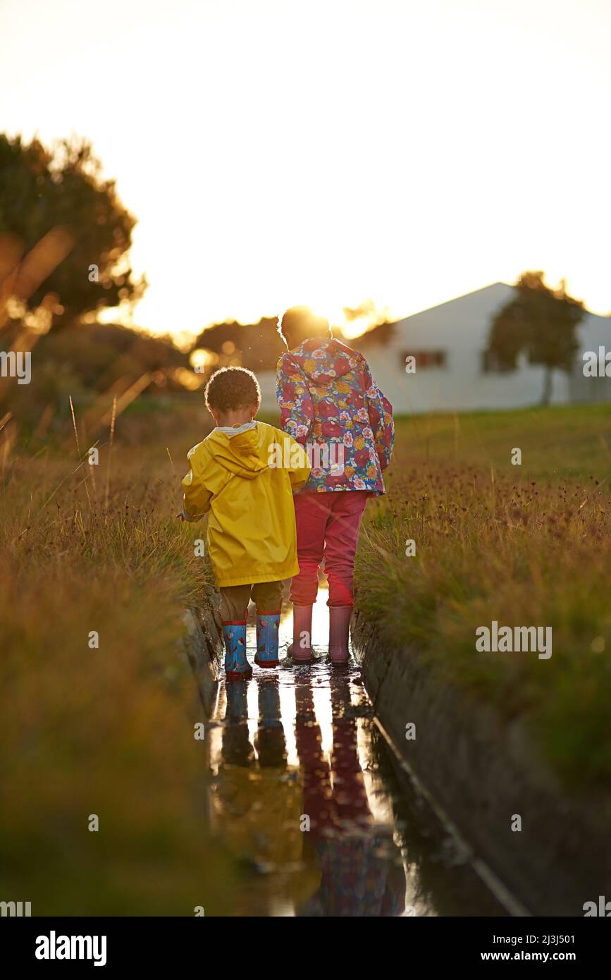 Splish splashing the day away. Shot of a brother and sister splashing in water while playing