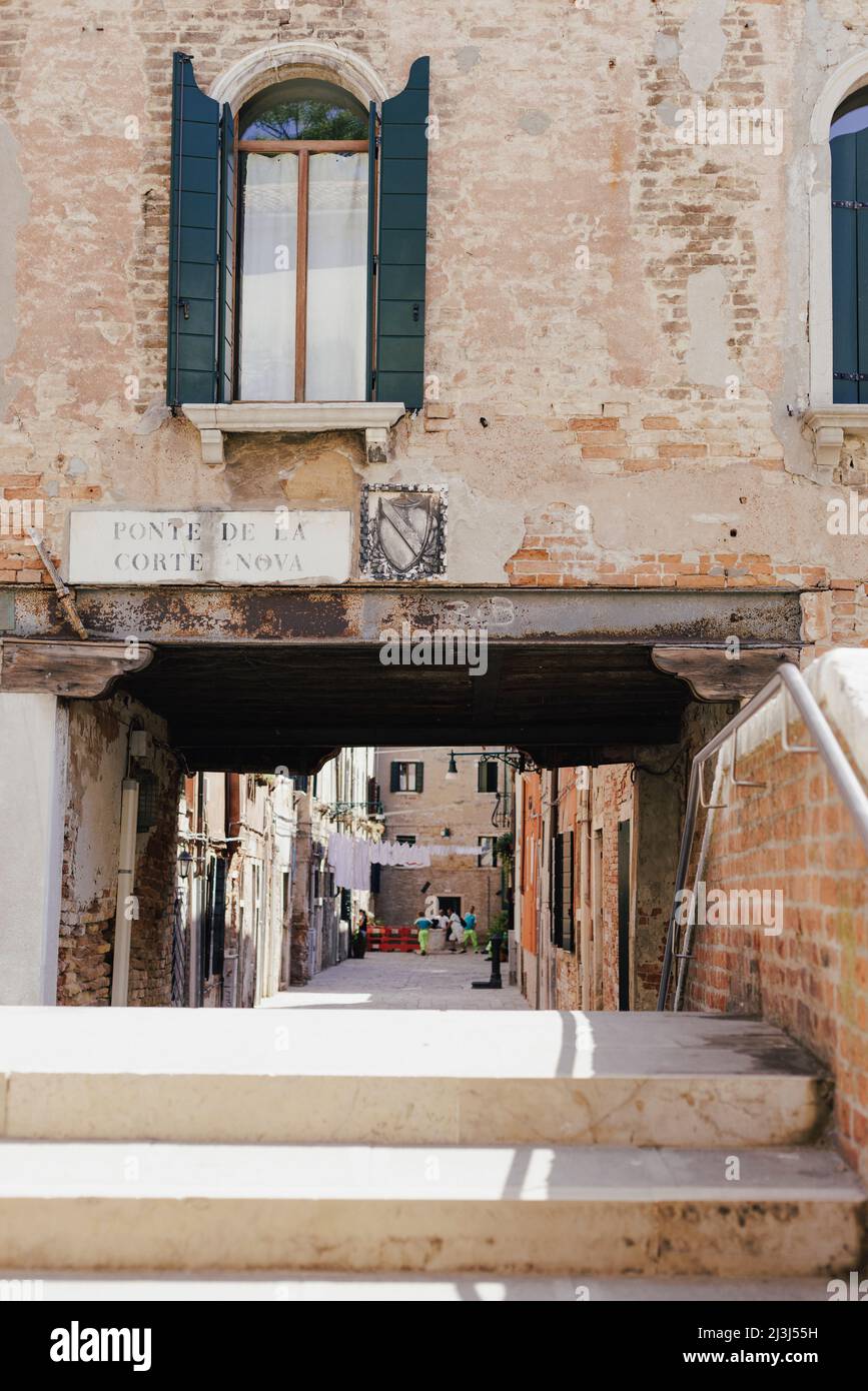 View over a Venetian bridge into a narrow alley in the Castello ...