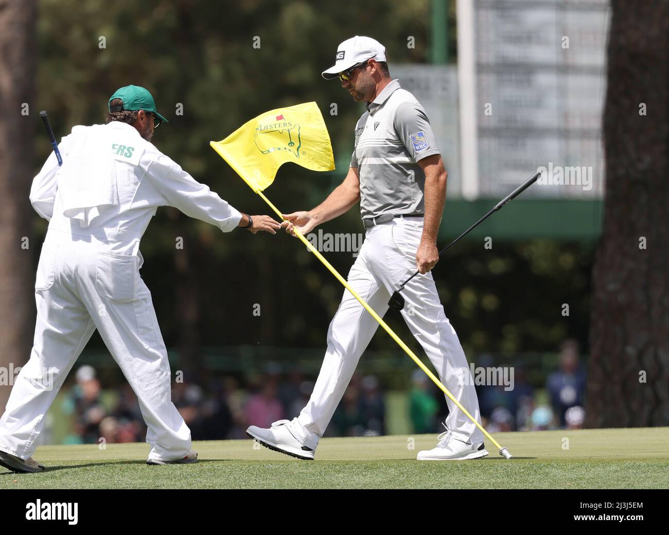 Golf - The Masters - Augusta National Golf Club - Augusta, Georgia, U.S. -  April 8, 2022 Canada's Corey Conners passes the pin flag to his caddie on  the 15th green during