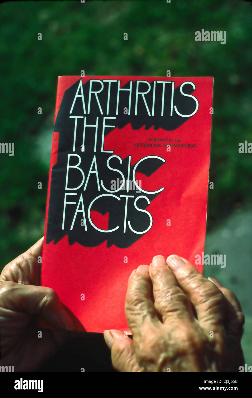 arthritic hands holding booklet, Arthritis the Basic Facts text