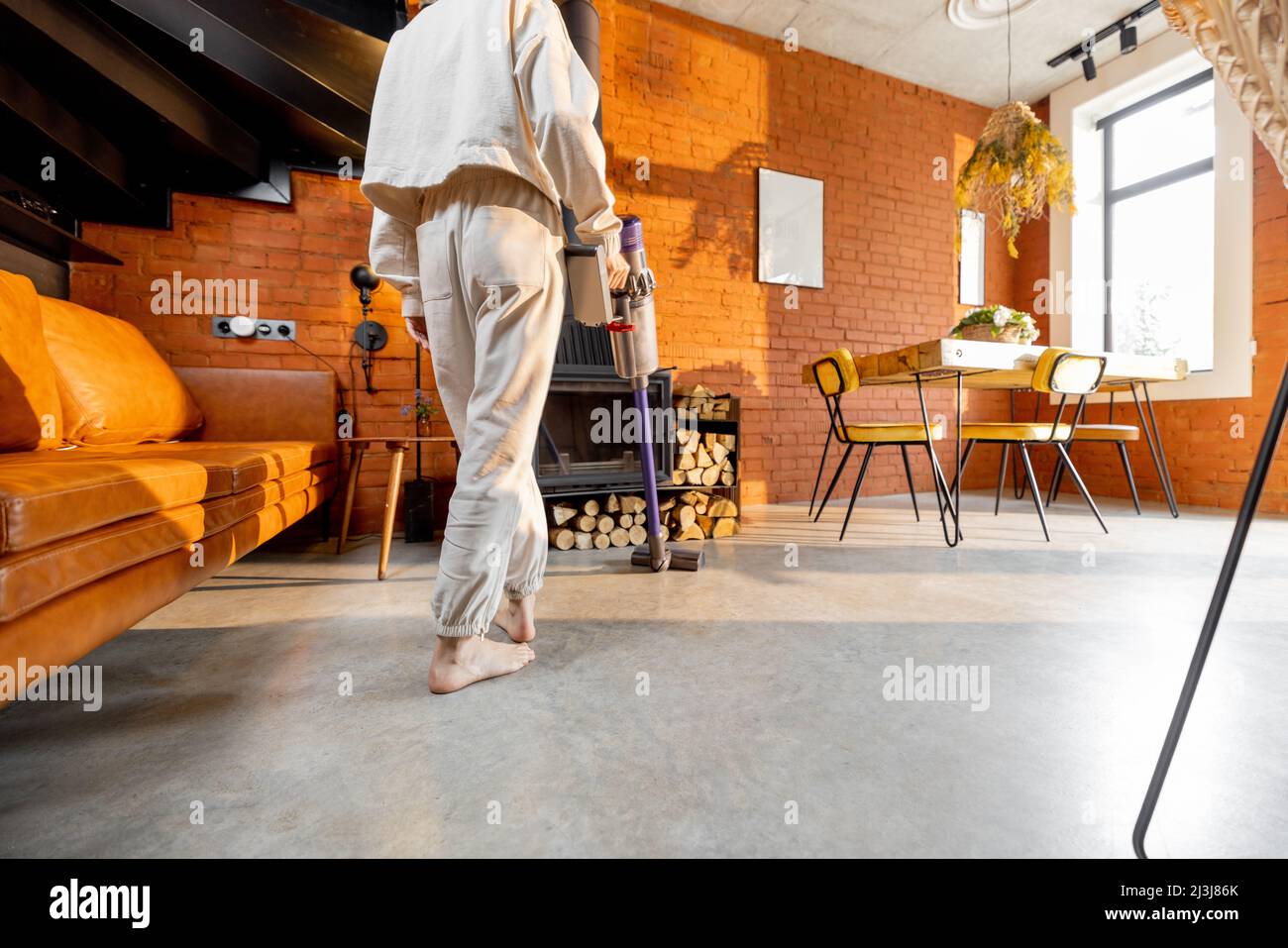 Woman cleaning floor with handheld vacuum cleaner Stock Photo - Alamy