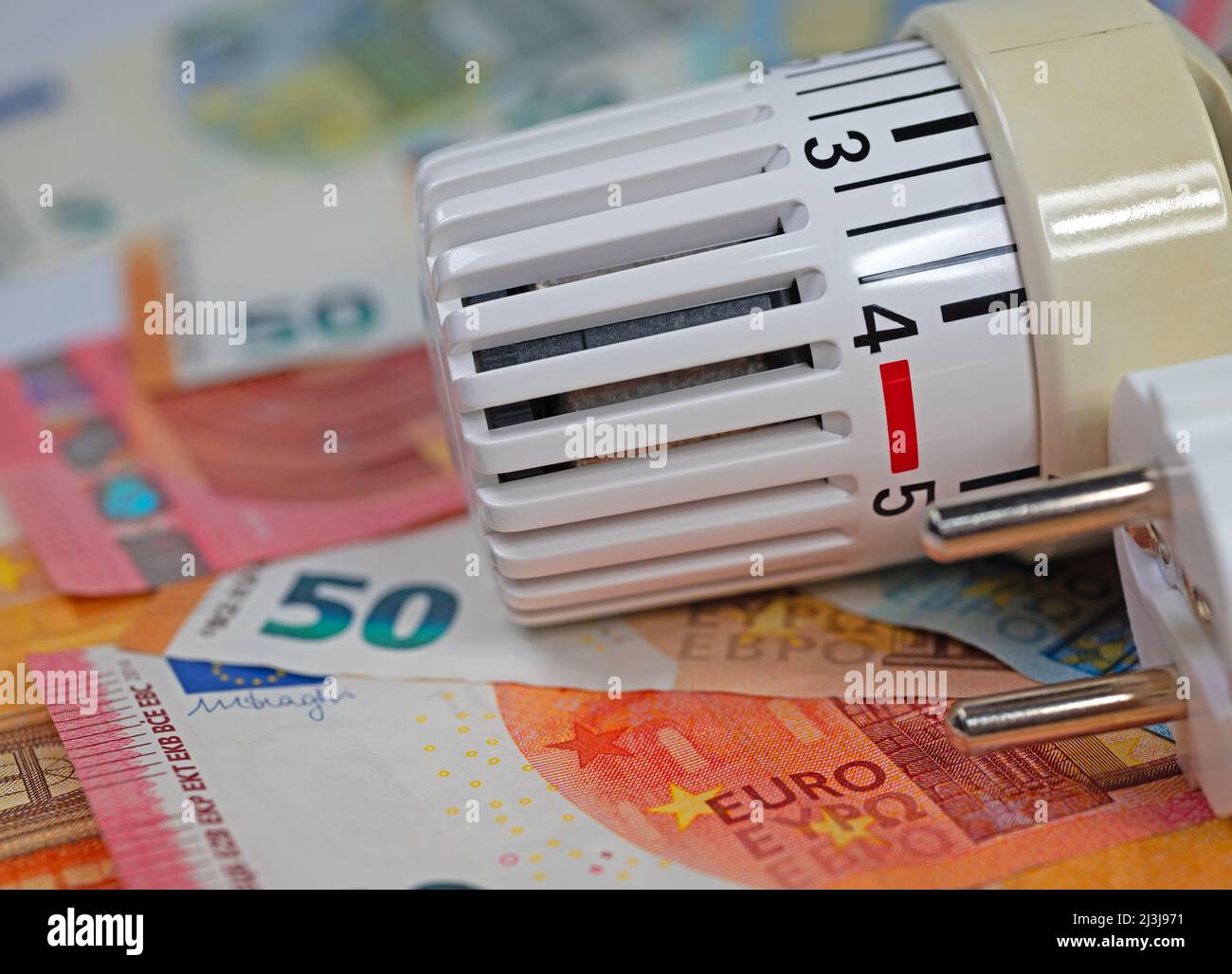 Thermostat in front of banknotes, symbolic of heating costs Stock Photo