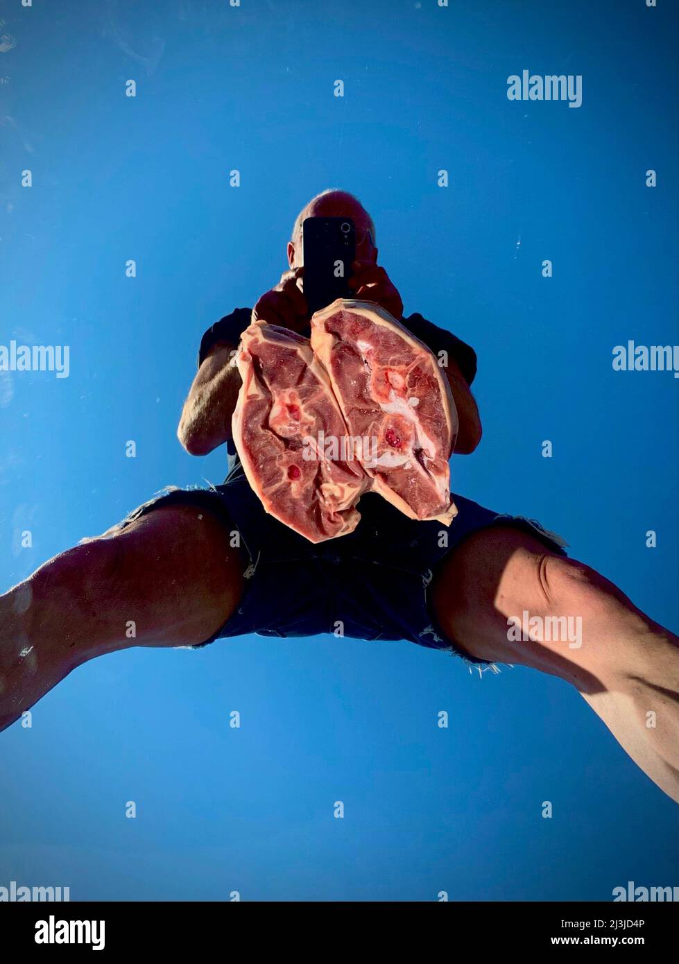 Man taking a selfie with steaks for barbecue. Stock Photo