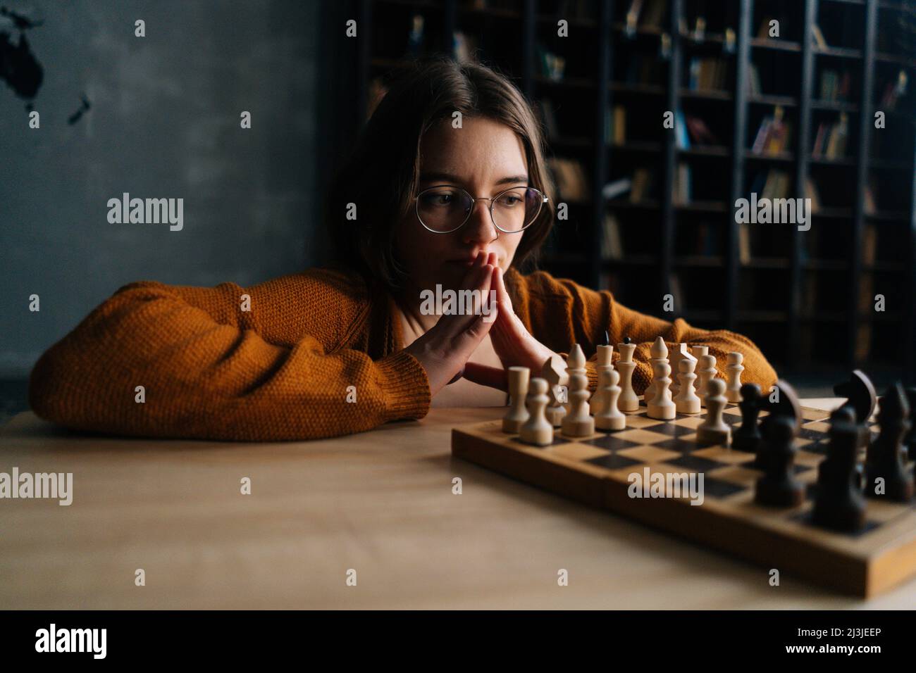 Woman playing chess thinking of next move Stock Photo - Alamy