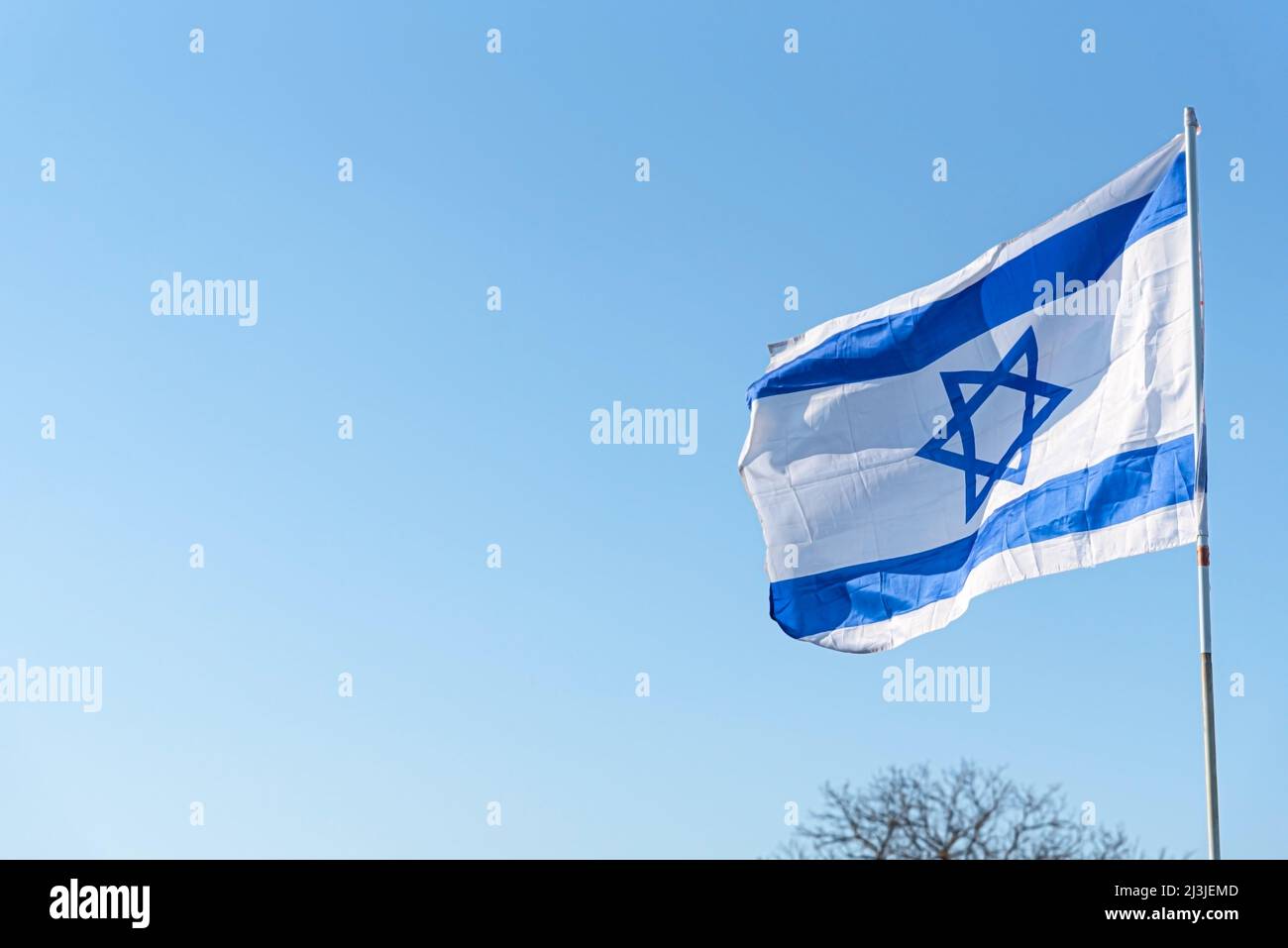 Flag of Israel on blue sky background. The Israeli Flag waving in the ...
