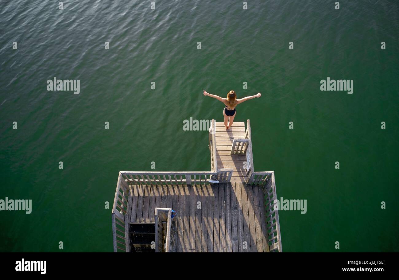 Woman on diving tower at lido Utting am Ammersee, Bavaria, Germany Stock Photo
