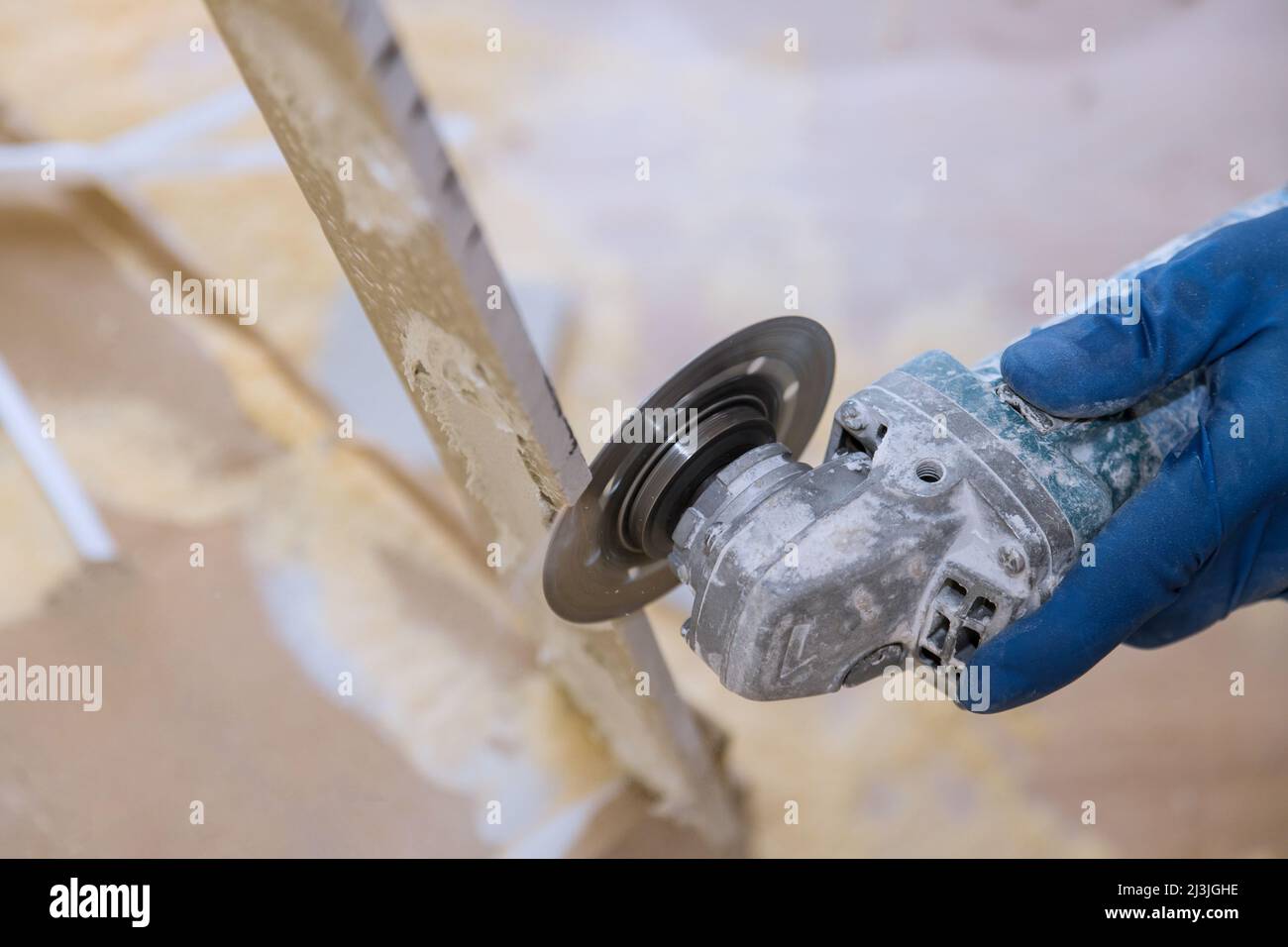 Worker hands cutting the floor ceramic tile by circular saw Stock Photo