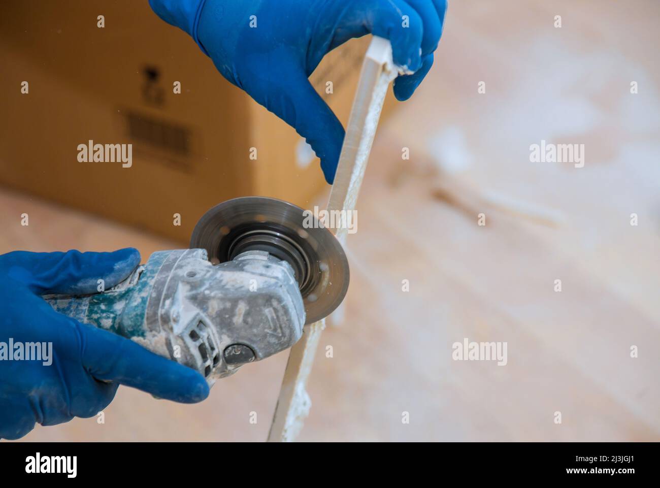Construction site with worker cutting a tile using an circular saw Stock Photo