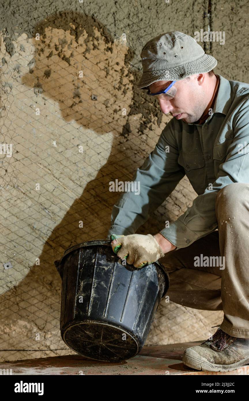 Black bucket with liquid mortar for the first layer of plaster for the