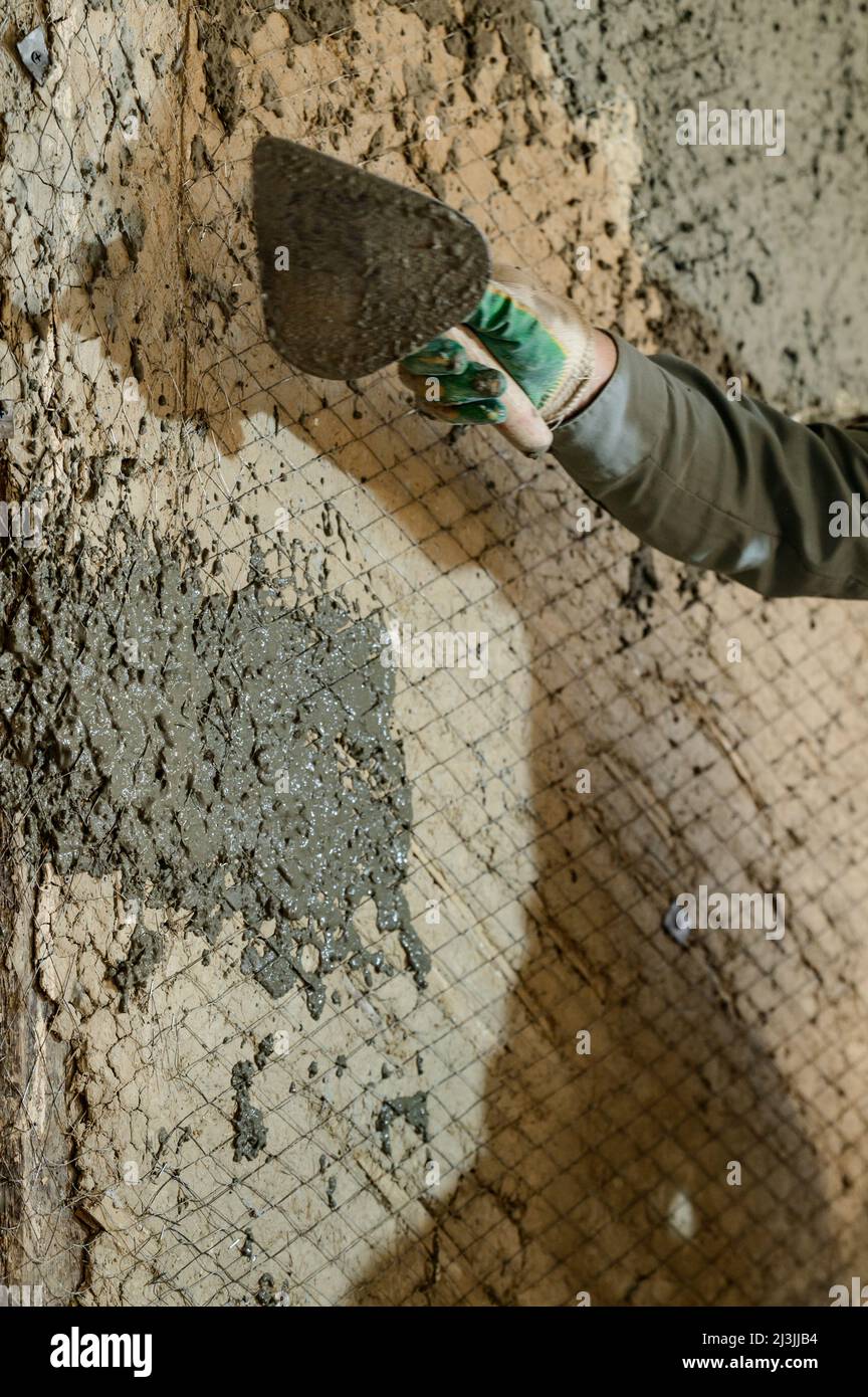 A man throws concrete mortar on the wall, the first layer of plaster on the  wall, repair work in Ukraine, single man makes repairs at home Stock Photo  - Alamy