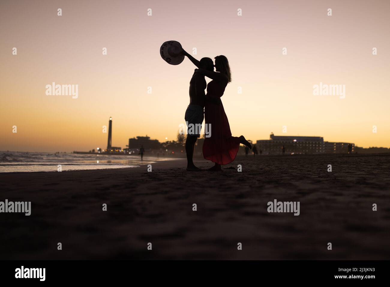 Silhouette of couple kissing on the beach at sunset Stock Photo - Alamy
