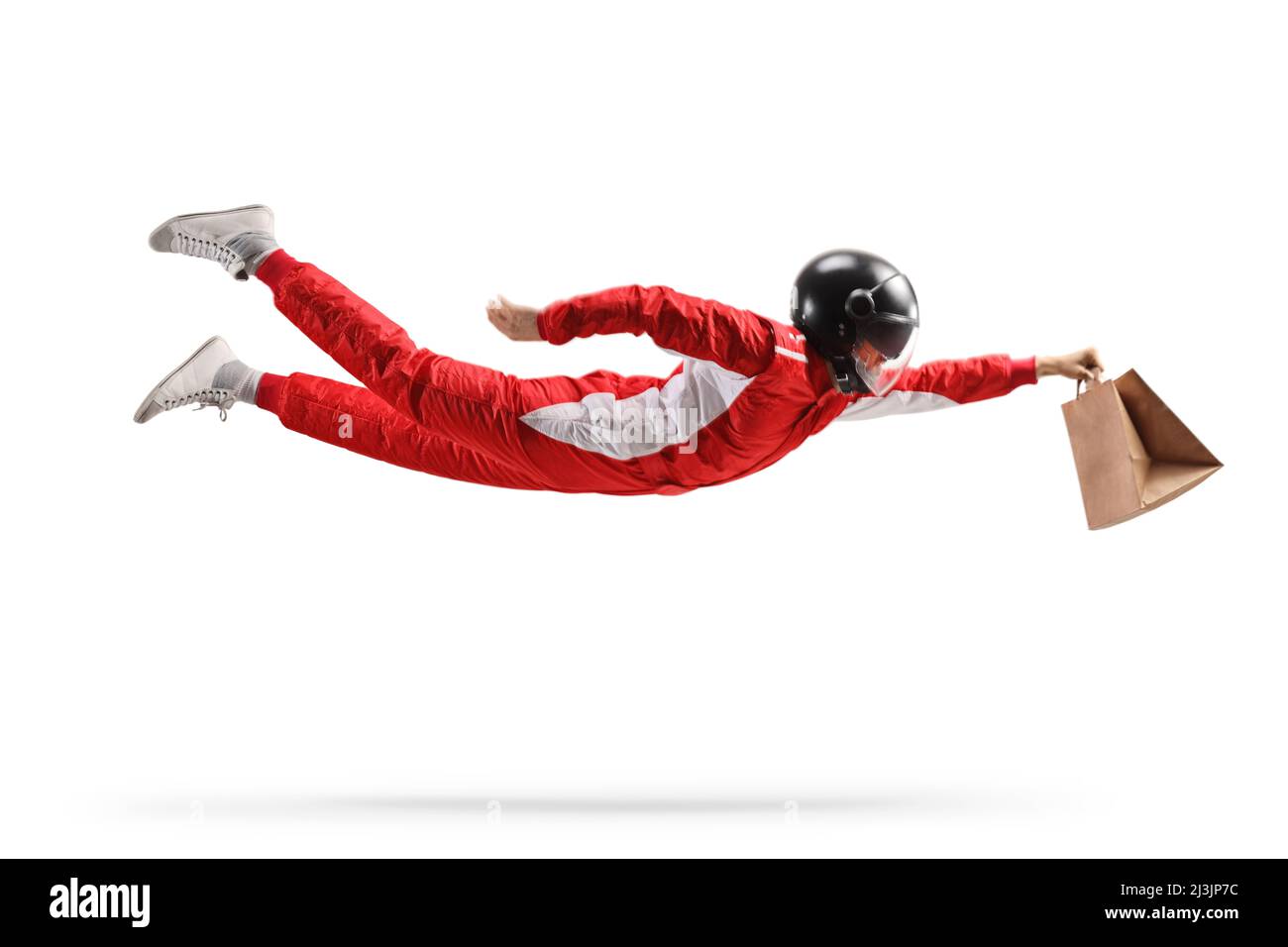 Racer in a red suit flying and carrying a fast food delivery bag isolated on white background Stock Photo