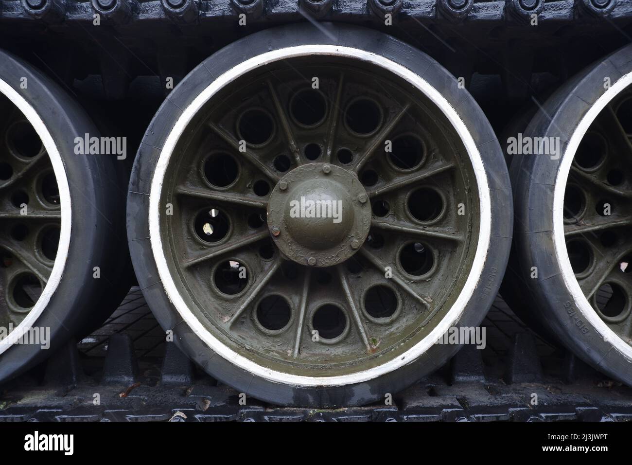 A fragment of the armored undercarriage of a tank with a caterpillar and wheels. Stock Photo