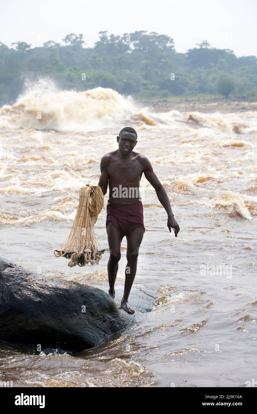 A Congolese fisherman prepares to throw his net from the shoreline