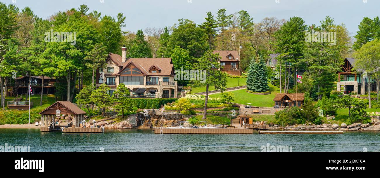 Waterfront houses and docks along an island shoreline in the Thousand Islands; Ontario, Canada Stock Photo