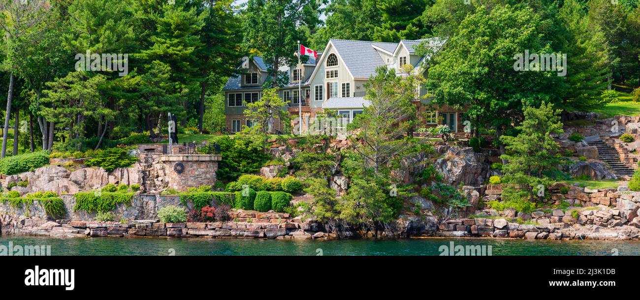 House with beautiful landscape design and a Canadian flag along an