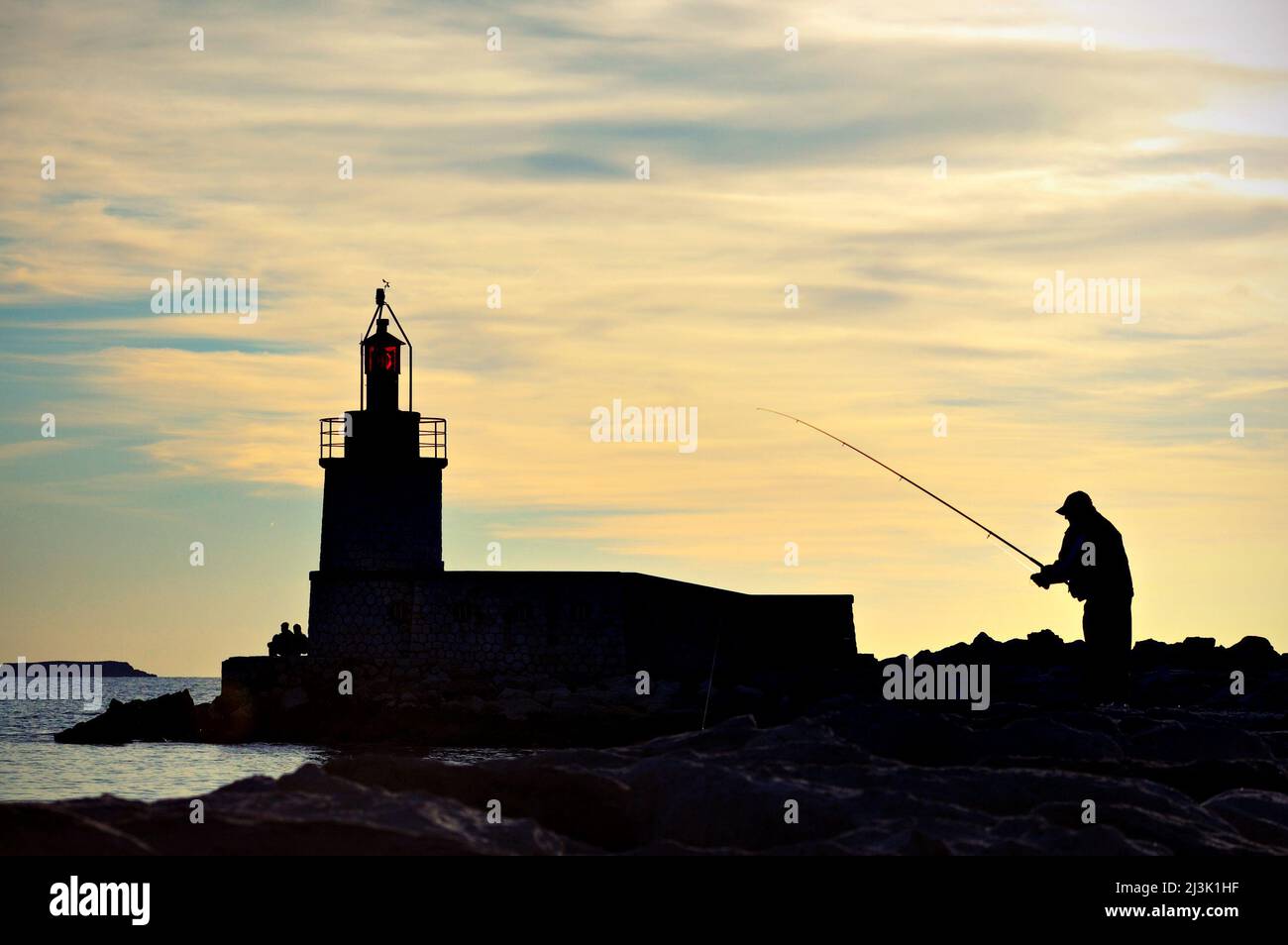 Fisherman by the lighthouse of Sanary-sur-Mer, Var, Provence-Alpes-Côte d'Azur, France Stock Photo