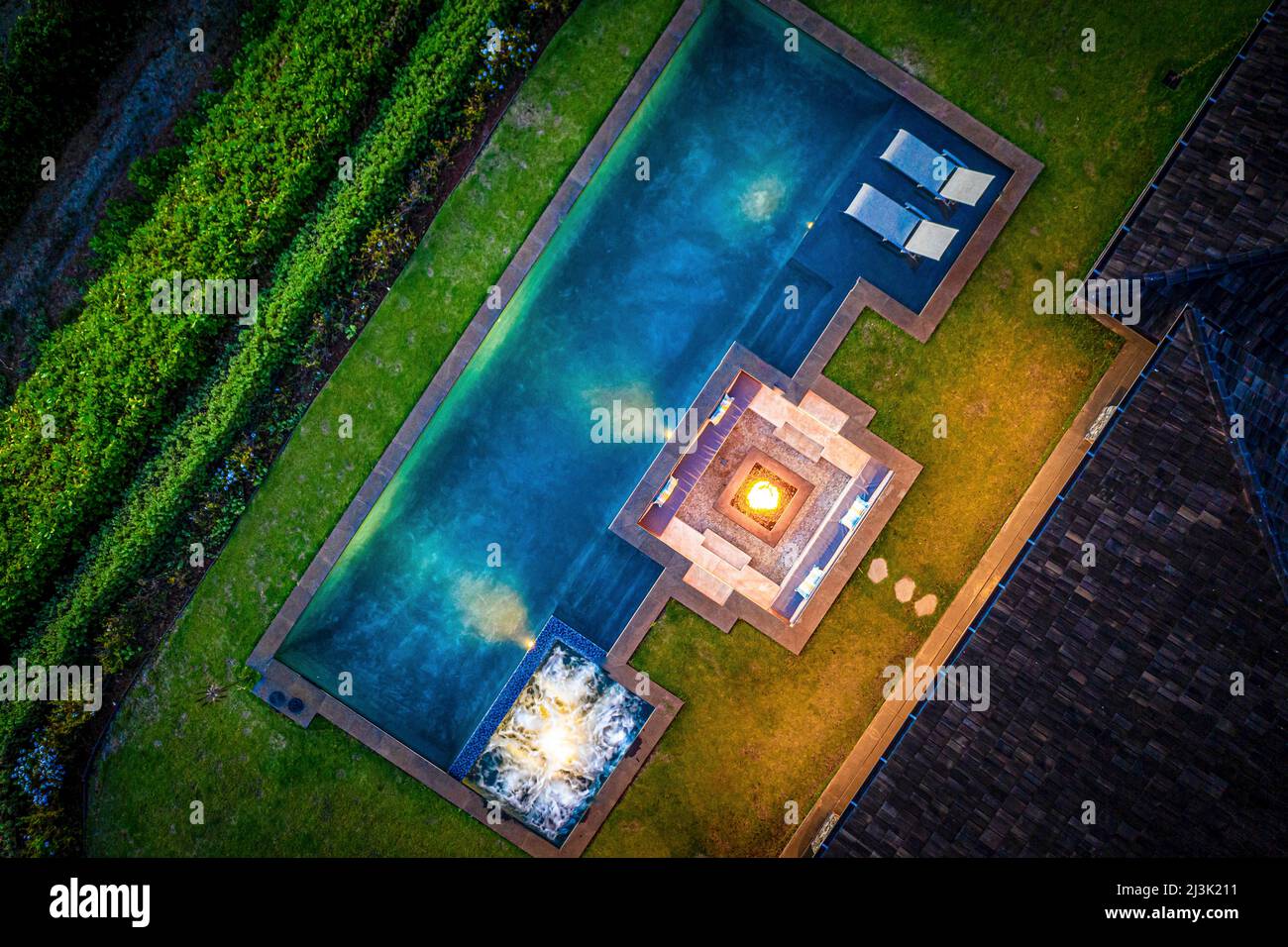 Drone view from directly above a swimming pool, building rooftop and lush vegetation on a property on the island of Maui, Hawaii, USA Stock Photo