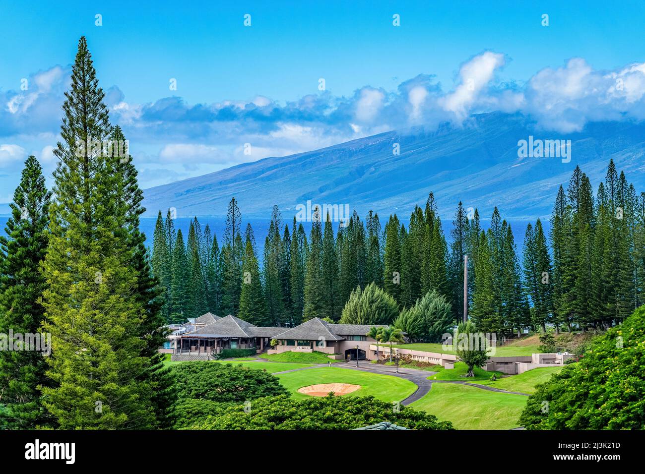 Golf course with buildings and tall trees on the island of Maui, with