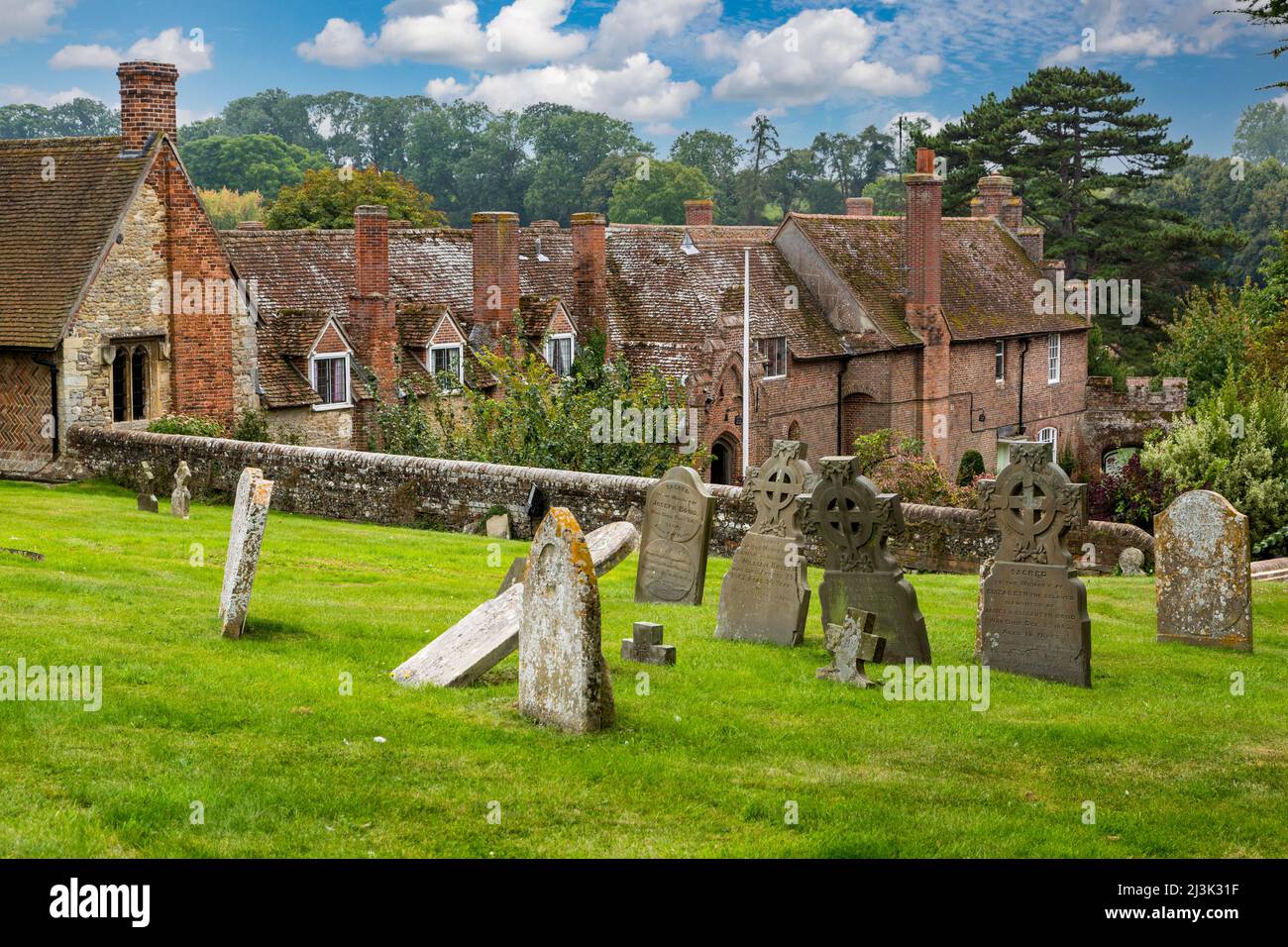 UK, England, Ewelme.  Graveyard of St. Mary the Virgin Church, with Almshouse and School in background. Stock Photo