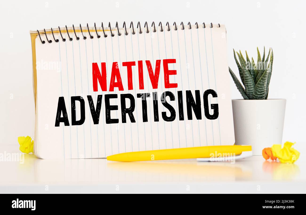 Text sign showing Native Advertising. Conceptual photo Online Paid Ads Match the Form Function of Webpage Scissors and writing equipments plus plain s Stock Photo
