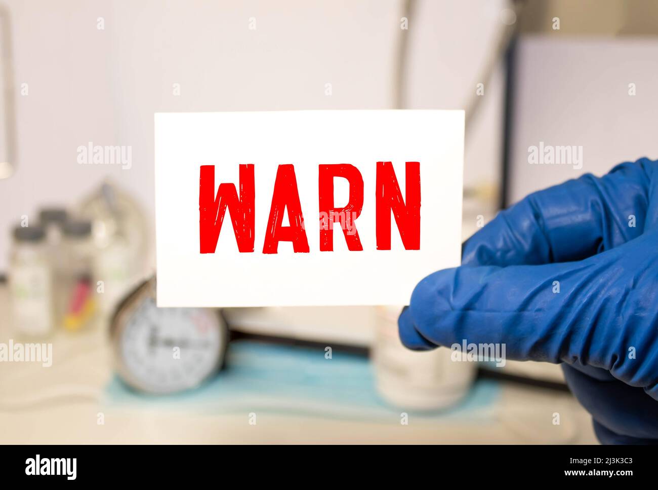 The word Warning on a white Notepad on a purple structural background