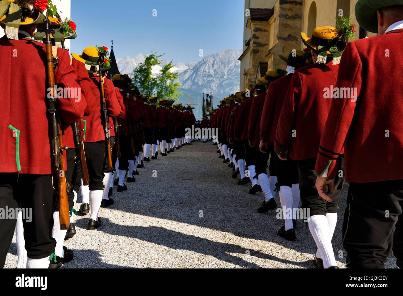 Lining up outside the Mary Immaculate parish church in Weerberg village, with the Karwendel mountain range in the background, local people of the area Stock Photo