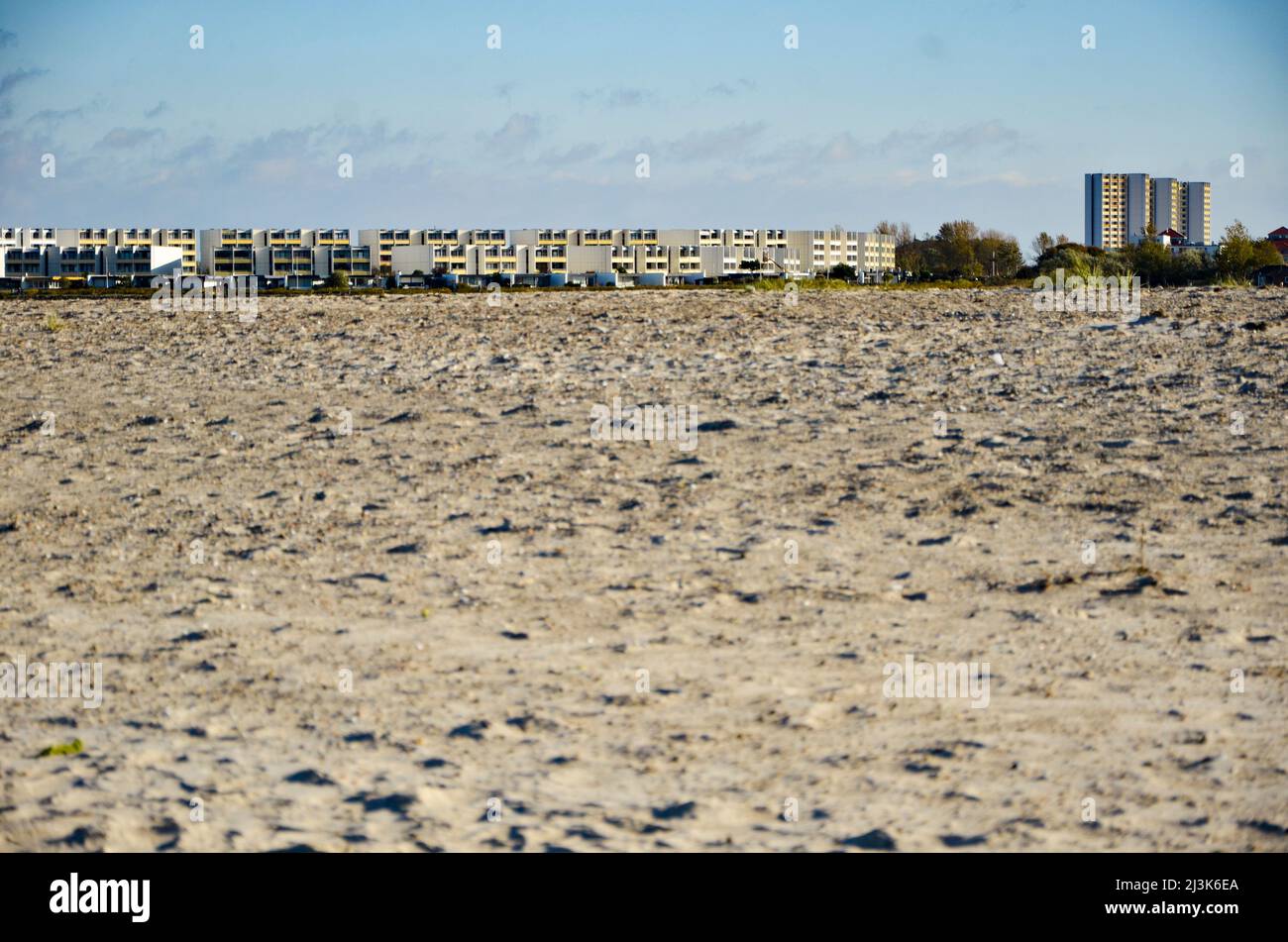 extensive sandy beach with holiday apartments and large Hotel on the horizon Stock Photo
