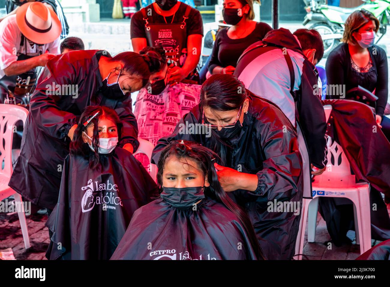 Young Peruvians having their hair cut off in Arequipa, Peru in response to a Social Media request for hair to soak up oil from the Callao oil spill. Stock Photo