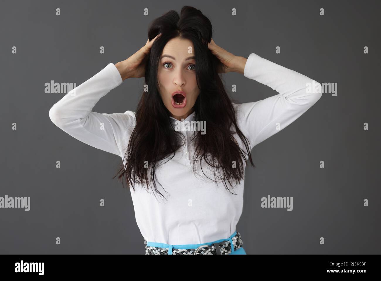 Portrait of young surprised woman on gray background Stock Photo - Alamy