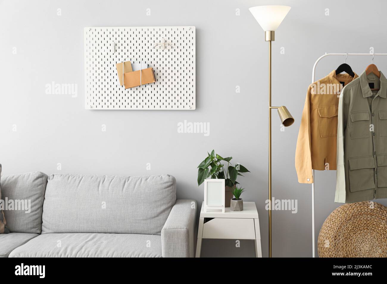 Interior of stylish living room with sofa, glowing lamp and stylish jackets Stock Photo