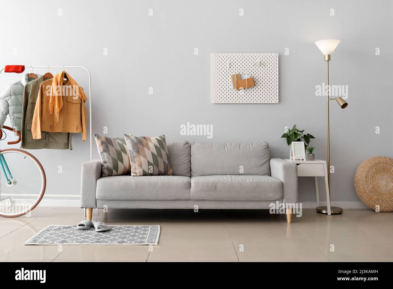 Interior of stylish living room with sofa, glowing lamp and stylish jackets Stock Photo