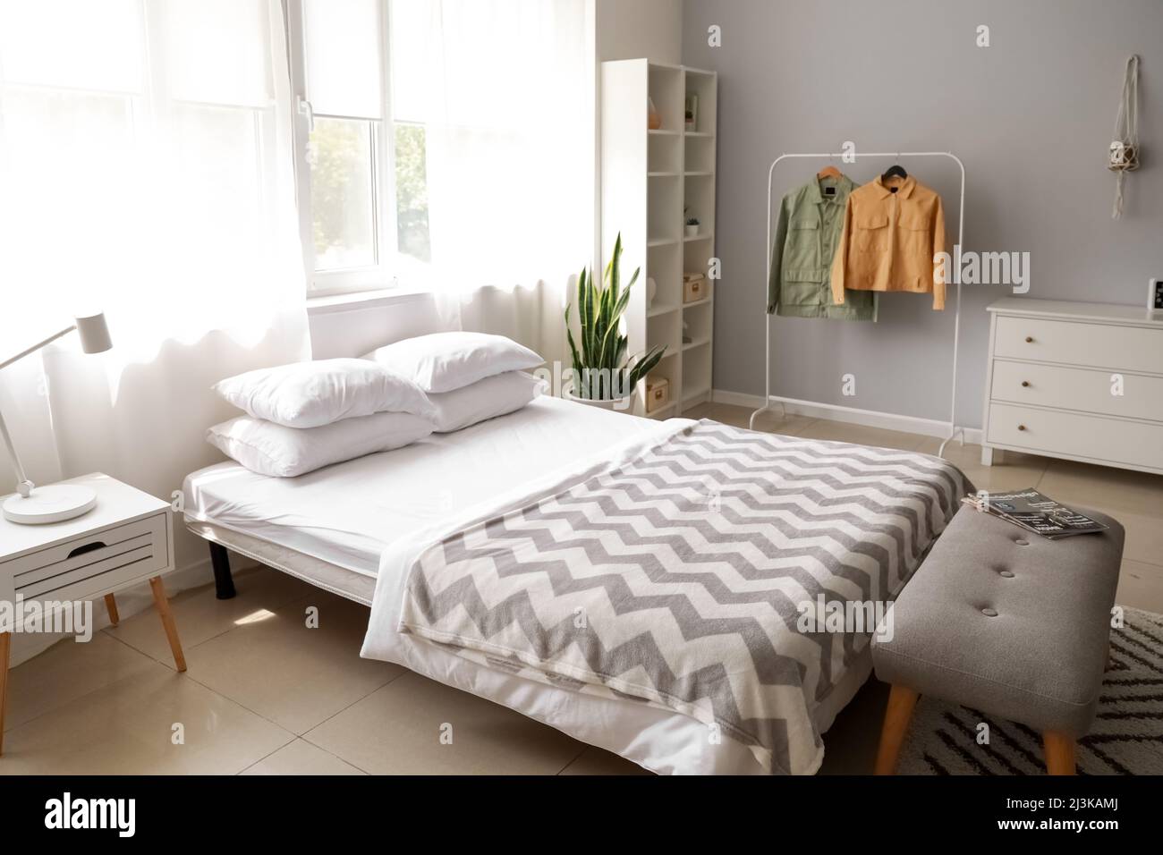 Interior of modern bedroom with rack and jackets Stock Photo