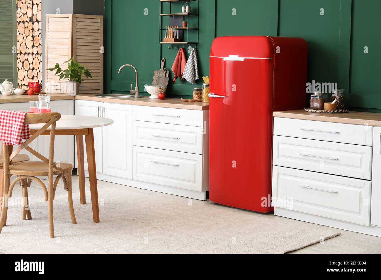 Interior of modern kitchen with dining table, stylish refrigerator and ...