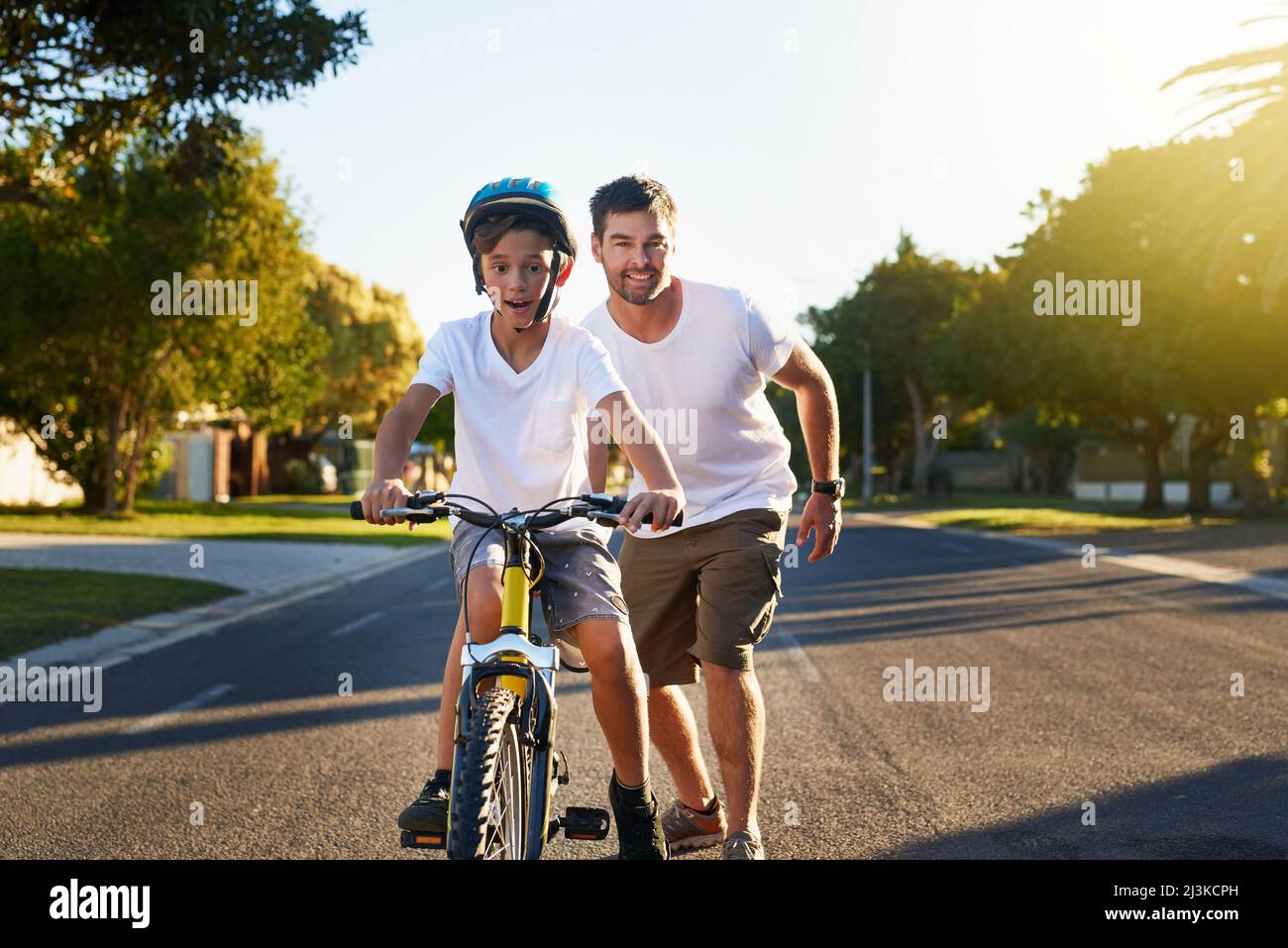 Cycling through his block. Shot of a young boy riding his bicycle through his neighbourhood. Stock Photo