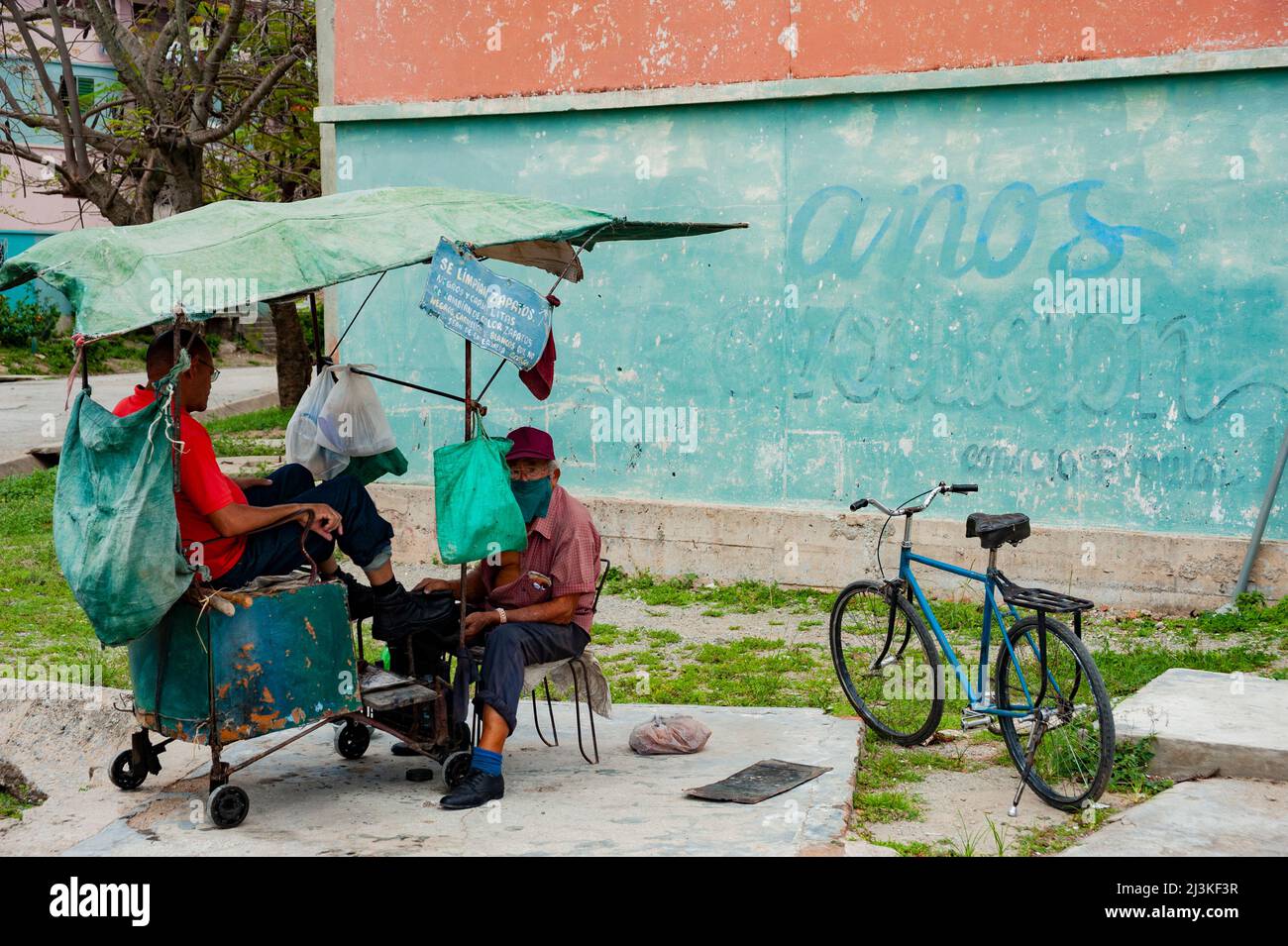 Shoeshine man works on customers boots in Havana, Cuba. Stock Photo