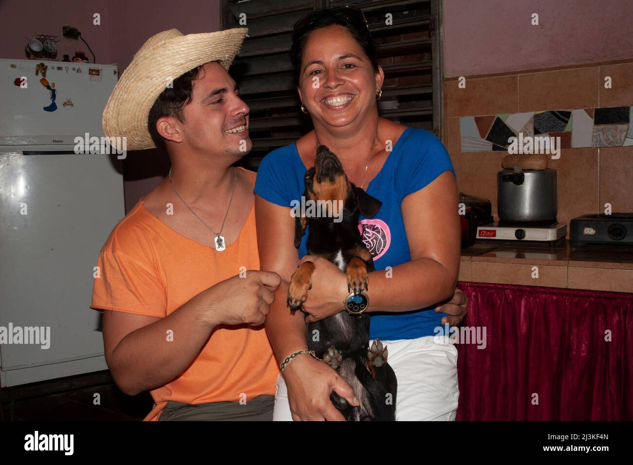 Family time with brother, sister and dog at home in the kitchen of their house in Trinidad, Cuba. Stock Photo