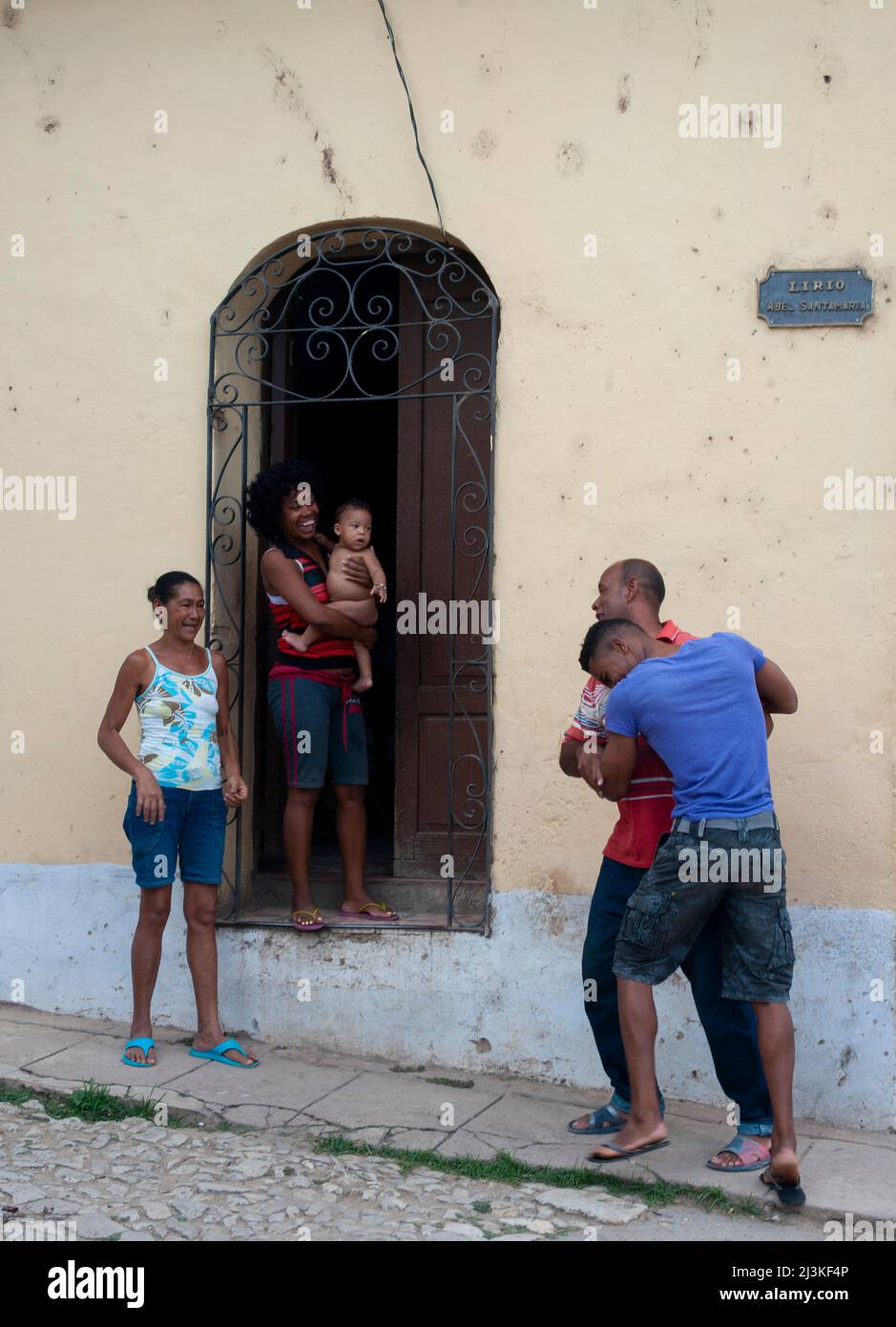 Family laughing and playing in the street in Trinidad, Cuba. Stock Photo