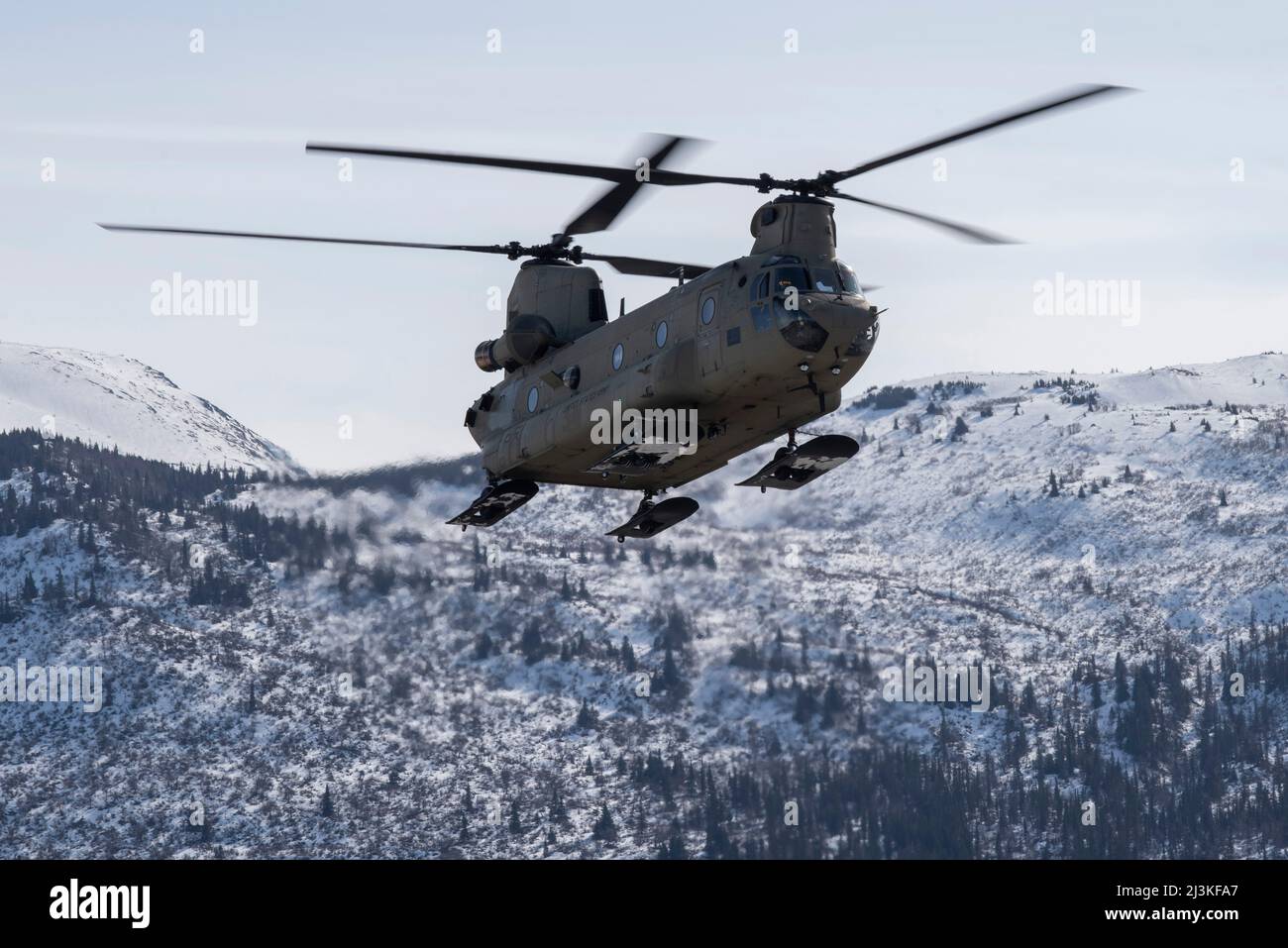 An Alaska Army National Guard CH-47 Chinook helicopter assigned to B Company, 2-211th General Support Aviation Battalion, flies over Bryant Army Airfield at Joint Base Elmendorf-Richardson, Alaska, April 7, 2022. The 2-211 GSAB supported a helicopter jump for the U.S. Air Force Detachment 1, 3rd Air Support Operations Squadron on Geronimo Drop Zone, maximizing total-force training to demonstrate short-notice mission readiness in an arctic environment. (U.S. Air Force photo by Senior Airman Emily Farnsworth) Stock Photo