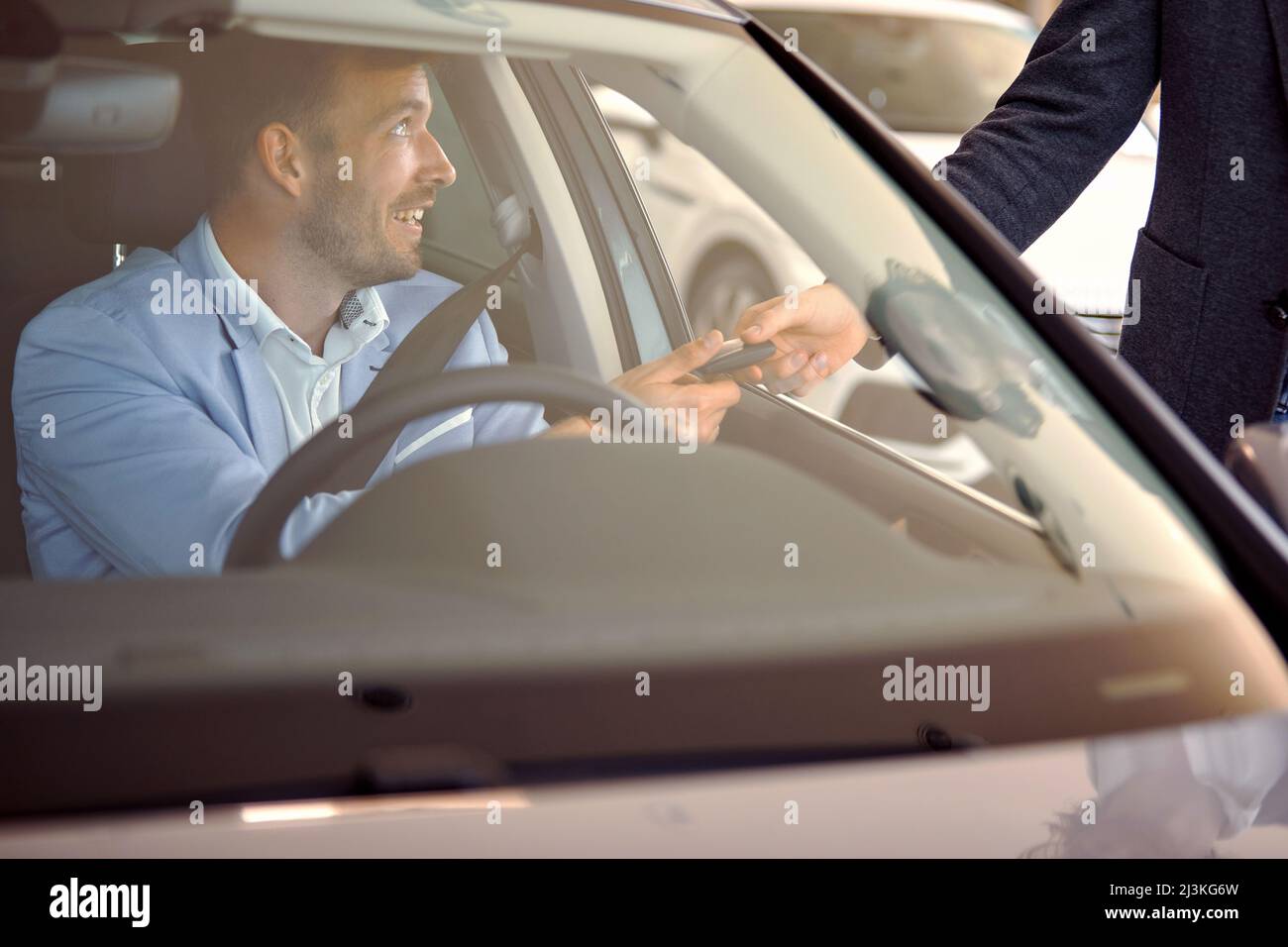 Buyer in car taking key of a new car from salesman in auto sales salon Stock Photo