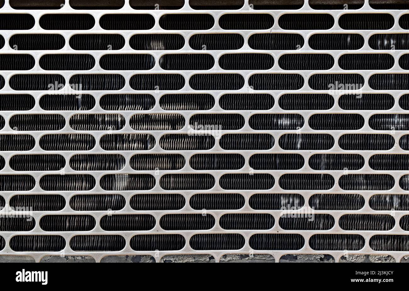 Perforated metallic surface texture background, grid on bus engine