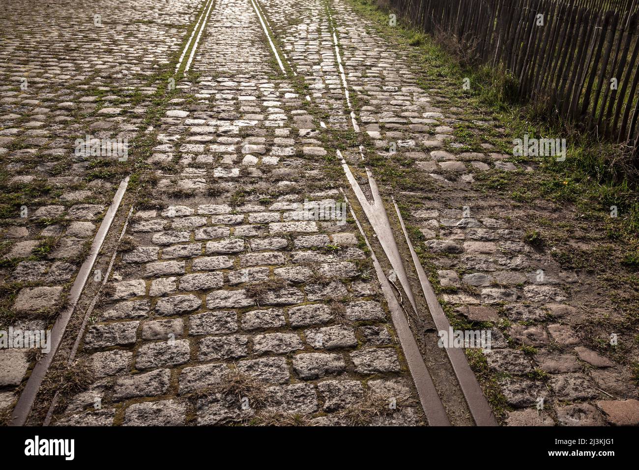 Picture of a tram track on a tramway on a cobblestone street of an urban downtown, neglected, abandoned, rusting and decaying. Stock Photo