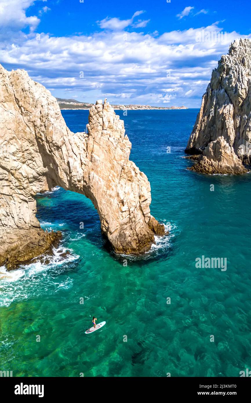 A woman paddles near the infamous Cabo arch. Stock Photo