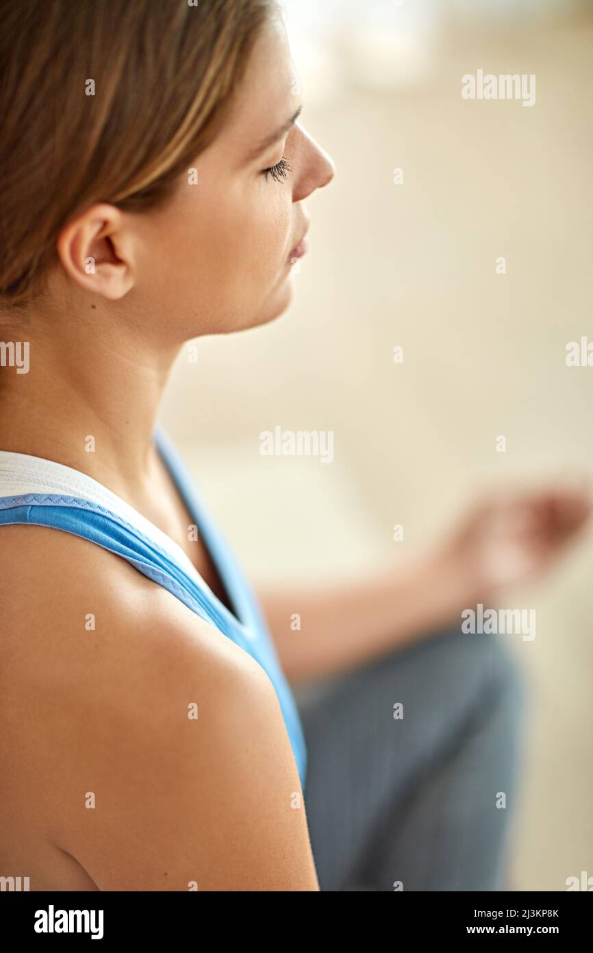 Getting in touch with her spiritual side. Cropped shot of a woman meditating indoors. Stock Photo