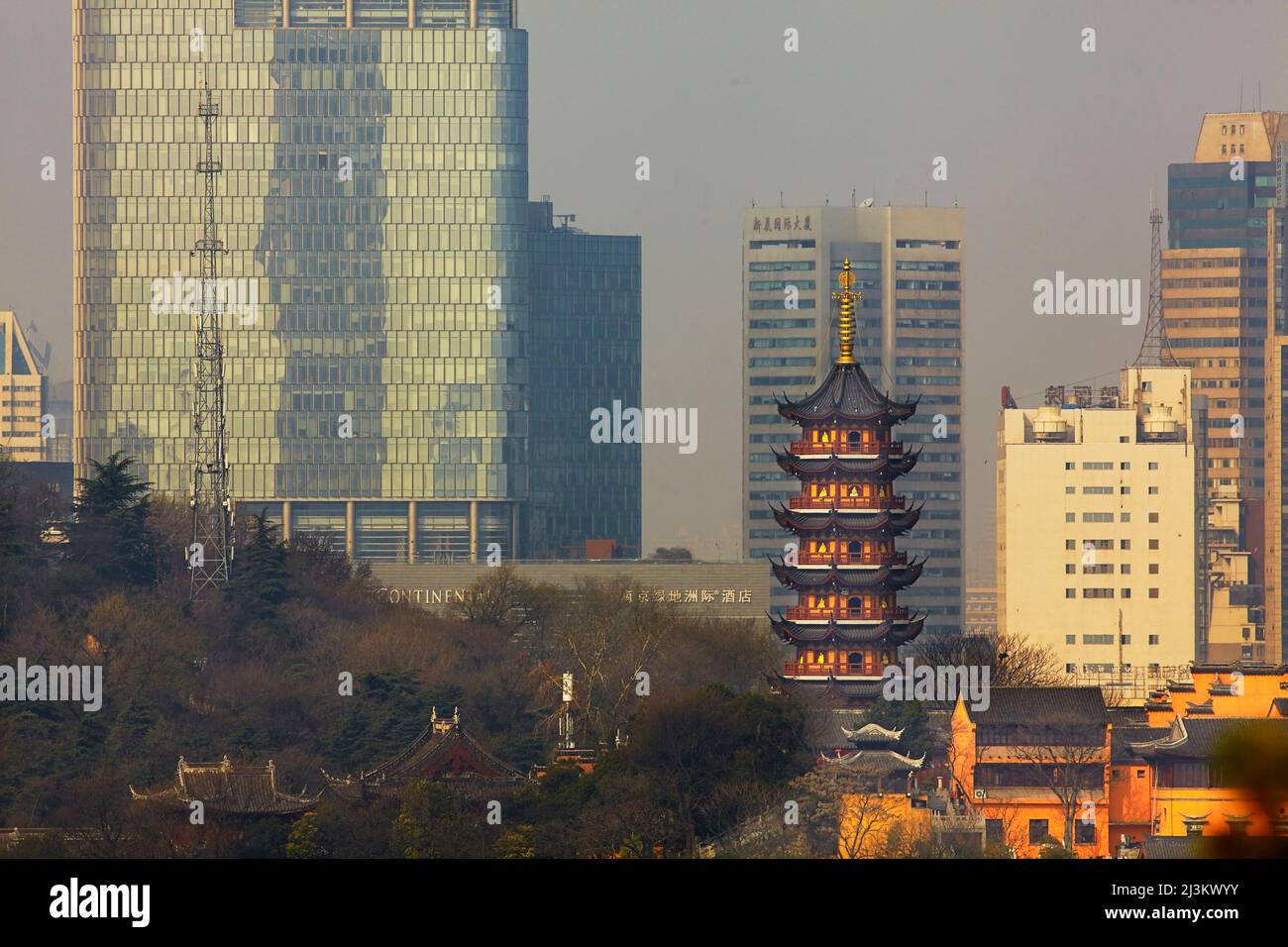 A Ming dynasty pagoda at Jiming Temple, with the modern city behind, Nanjing, Jiangsu province, China. Stock Photo