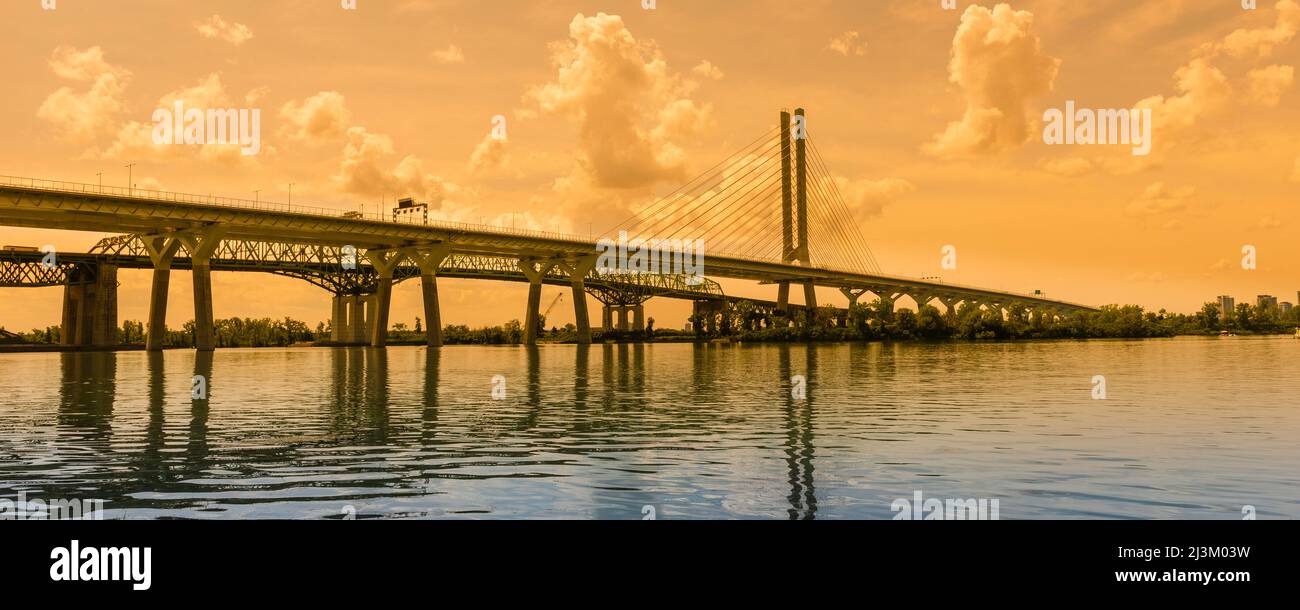 Samuel De Champlain Bridge over the St. Lawrence River with a golden sky at dusk; Montreal, Quebec, Canada Stock Photo