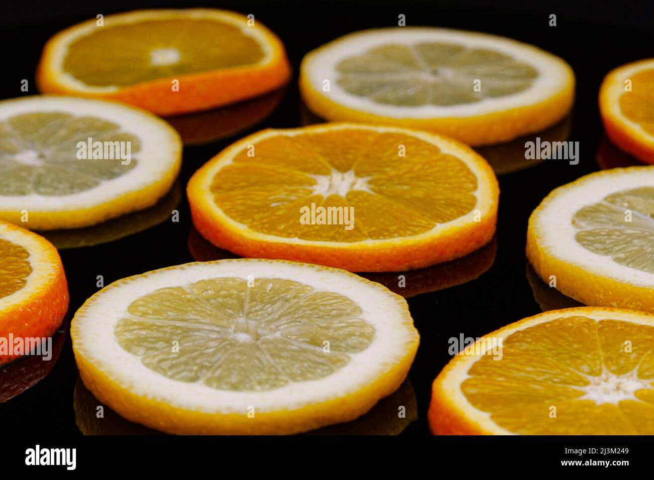 Citrus slices on a black background. Slices of organic orange and lemon.  Yellow orange abstract Stock Photo