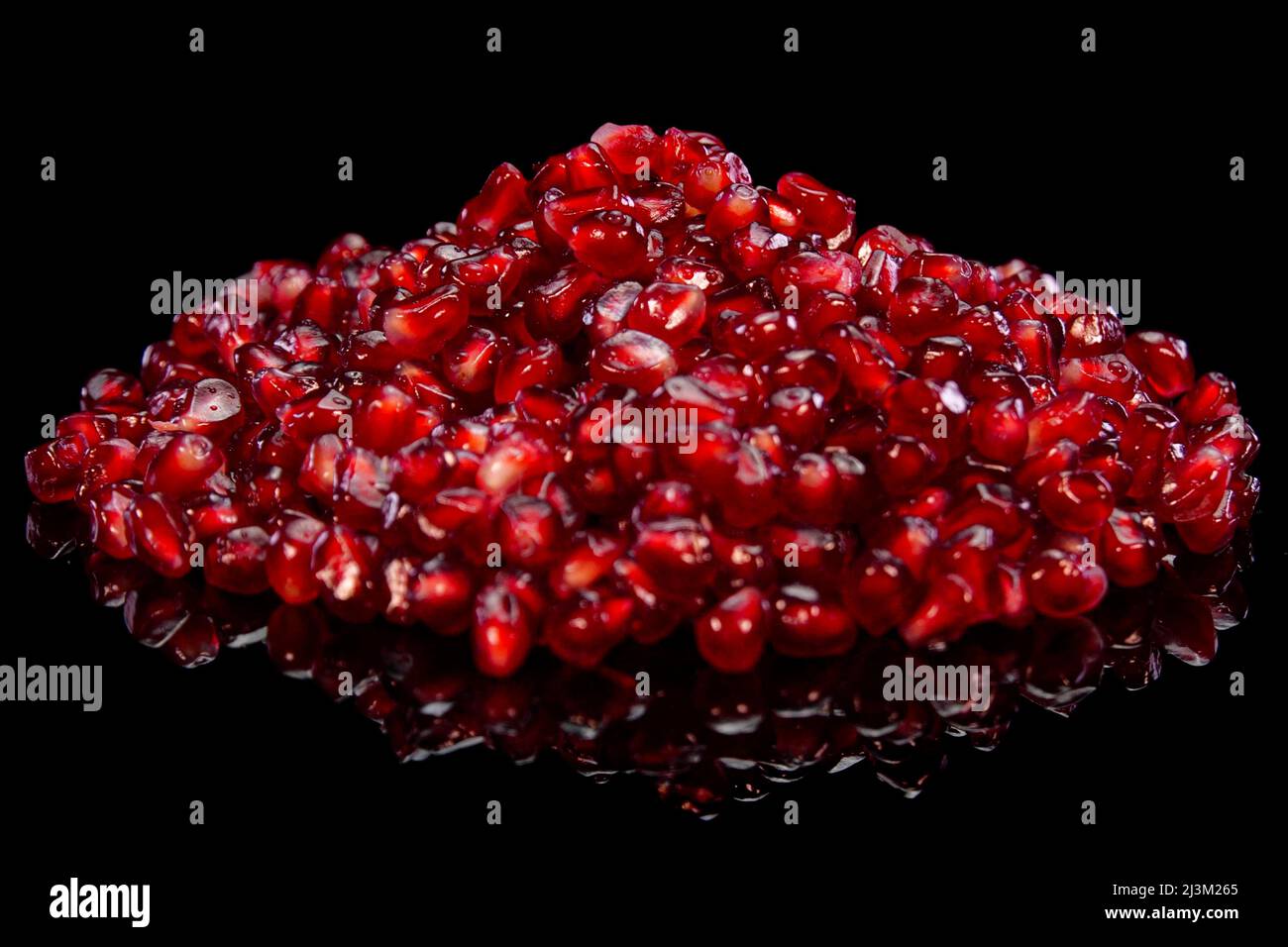 Heap of pomegranate grains close up. Red seeds of grenade macro view. Stock Photo